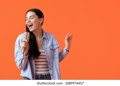 Singing Young Woman With Hair Brush On Color Background