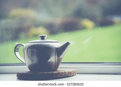 Single alone tea pot at window in kitchen