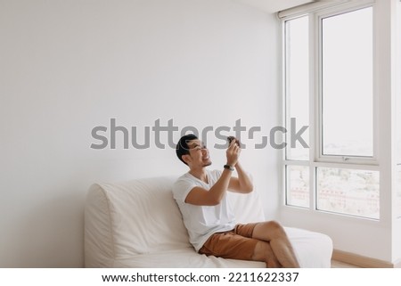 Single asian man playing with his sugarglider pet alone in his apartment. High quality photo