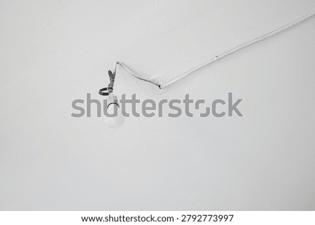 Single bare light bulb hanging from the ceiling in a minimal interior space