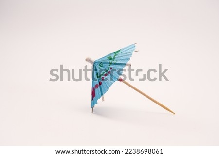 Single blue cocktail parasol umbrella isolated on a white background side view 