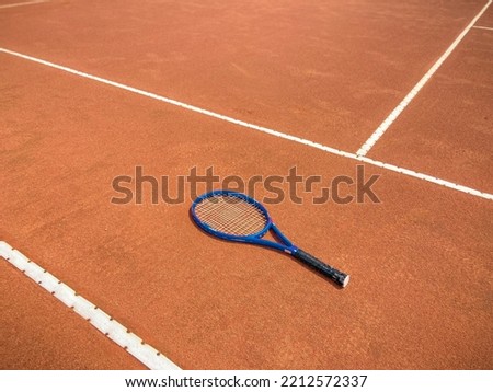 Single blue Racket on brick dust clay tennis court professional image isolated Wimbledon championship brown texture sport white lines background beautiful background tennis equipment