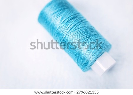 Single blue thread spool on white surface, sewing, thread, craft