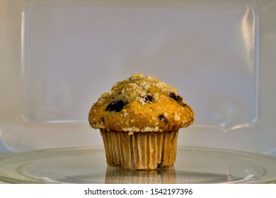 Single Blueberry Muffin Isolated In A Microwave Oven Carousel At Eye Level With Copy Space.