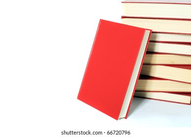 Single Book Stands Next To A Pile Of Books. All On White Background. Extra Text Space On Left Side.