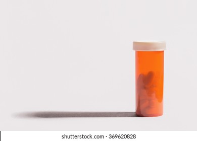 Single Bottle Of Prescription Painkillers On White Background With Long Shadow.
