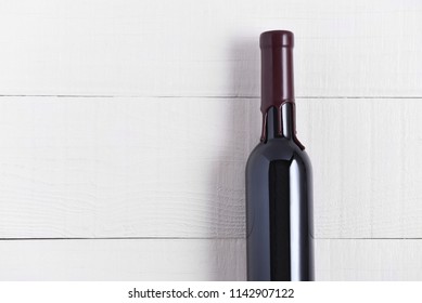 Single Bottle of Wine on a White Wood Table. The thin bottle has a wax seal over the top. - Powered by Shutterstock