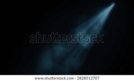 A single bright spotlight beam cuts through the darkness, illuminating faint smoke particles and creating a dramatic effect.