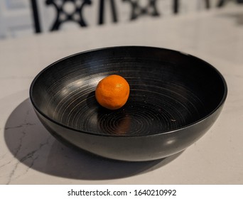 Single Bruised Orange In An Otherwise Empty Fruit Bowl.