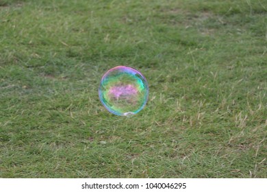 Single bubble floating through the grey overcast sky 