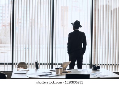 Single Businessman In Stylish Outfit Waiting For Meeting. Back View Photo.copy Space. Mafia Standing Near The Window