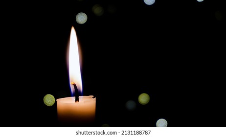 A single candle burns. Close-up of a white wax candle in the dark. Tragedy. Memory. War and death. Fire in the temple on the altar. Religion. Life without electricity. Energy Crisis on Earth. memory 