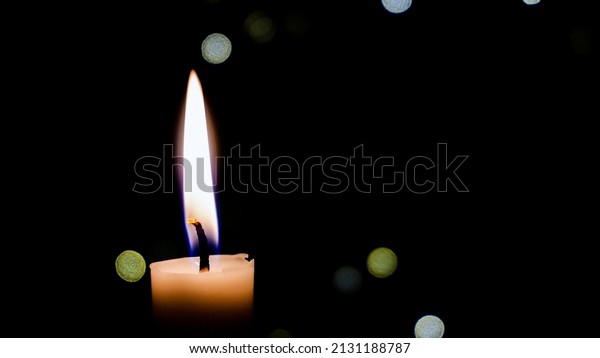 A single candle burns. Close-up of a white wax candle in\
the dark. Tragedy. Memory. War and death. Fire in the temple on the\
altar. Religion. Life without electricity. Energy Crisis on Earth.\
memory 