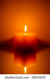 Single Candle On Orange Background