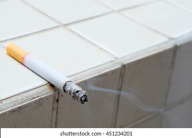 Single cigarette with ash abstract background