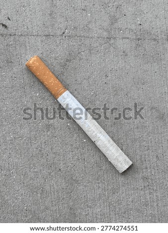 Single cigarette lying on the ground