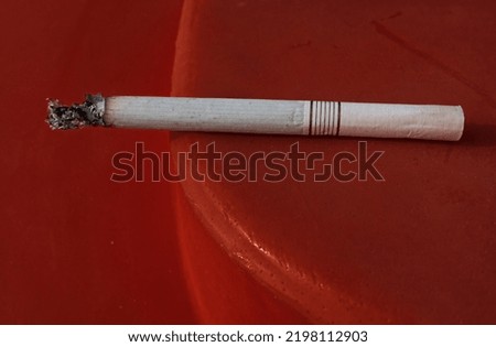 single cigarette view, close up, filter, red background