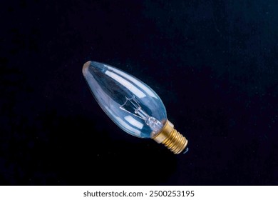 A single clear light bulb against a dark background. - Powered by Shutterstock