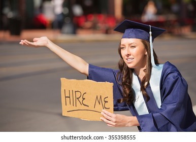 Single College Graduate In Gown Holding Hire Me Sign