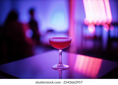 A single coupe glass filled with a vibrant red cocktail sits elegantly on a reflective surface. The neon lights in shades of purple and pink create a moody, upscale nightlife ambiance - Powered by Shutterstock