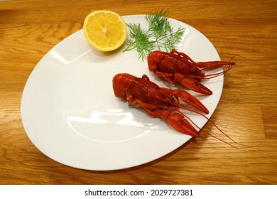 A single crayfish plate with lime and dill for decoration.  Inside at a kitchen table. Diet plate with only two cray fish. Aerial view. Stockholm, Sweden.