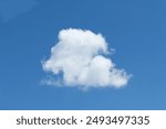 Single cumulus cloud with blue sky background