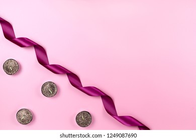 Single Curly Lace Ribbon And Tea Light Candles  On A Pink Background With Copy Space. Festive Minimalist Mockup For A Giftcard Or A Postcard.