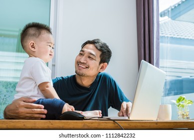 Single Dad And Son Using Laptop Together Happily. Technology And Lifestyles Concept. Happy Familly And Baby Theme.