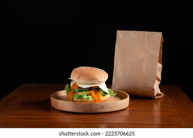 A Single Delicious Hamburger With Package  In A Black Background