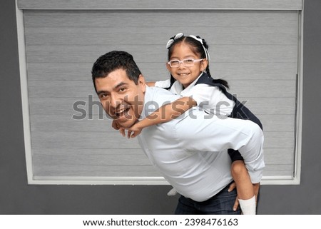 Single divorced dad and 4 year old daughter in school uniform brunette Latinos play and spend time together after school celebrating Father's Day