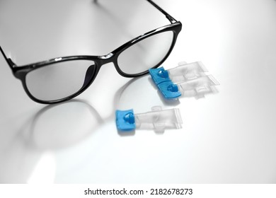 Single Dose Eye Drops And Glasses On White Table