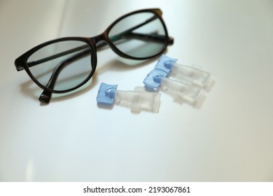 Single Dose Eye Drops And Glasses On White Table