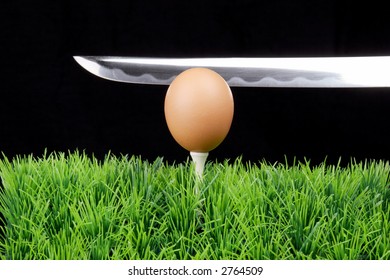 Single Easter Egg on a golf tee at the fairway, black background, long sword behind