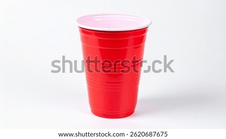A single, empty, bright red plastic party cup with a white rim sits on a white background. Its ribbed and disposable.