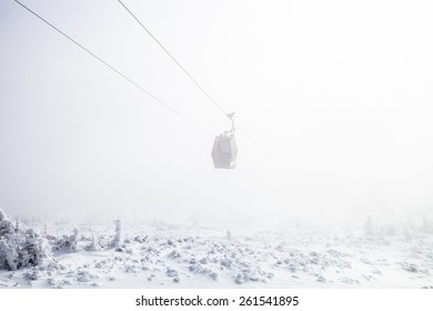 Single empty cableway in the mist in winter - Shutterstock ID 261541895