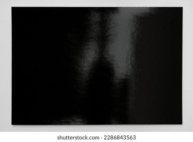 single empty dark shiny Photopaper piece on white background, nice photo or poster overlay.