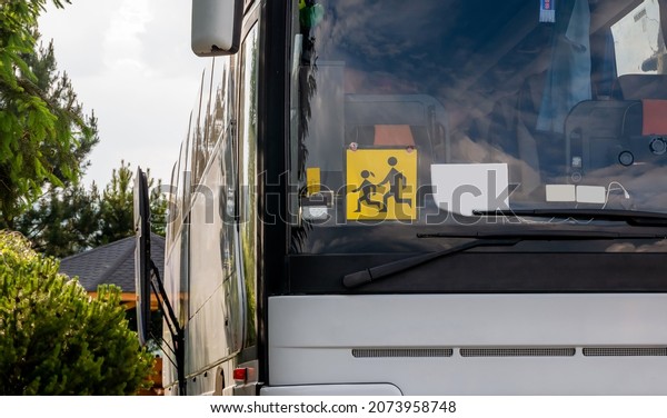 Single empty modern school trip bus, kids\
transport designated coach vehicle detail, closeup, nobody, frontal\
shot. Children journey safety concept. Traffic, transportation,\
means of transport