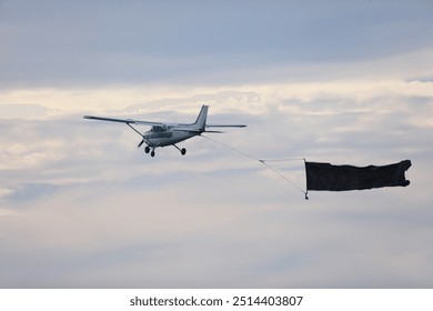 single engine airplane in flight with a poster