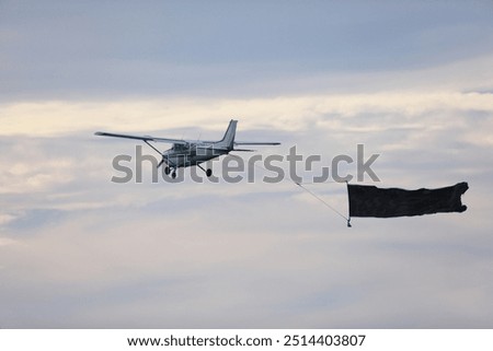single engine airplane in flight with a poster