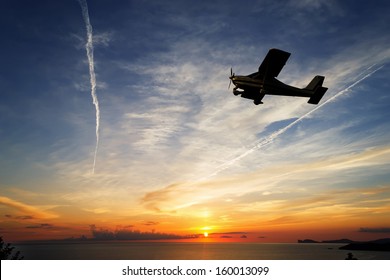 Single Engine Airplane Flying At Sunset