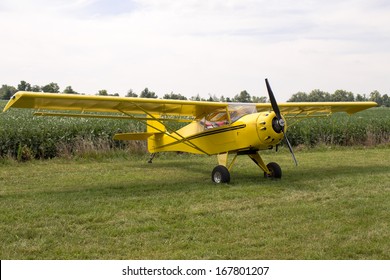 Single engine fixed wing aeroplane parked on a green grass field on display during a rural airshow