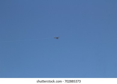 A single engine prop plane flying in a clear blue sky.