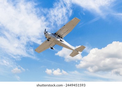 Single engine ultralight plane flying in the blue sky with white clouds	