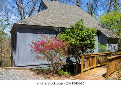 Single Family Mountain Vacation Rental House With Gravel Road Driveway In Spring At Wintergreen Ski Resort Town City Of Nelson County, Virginia With Azalea Rhododendron Bush Tree