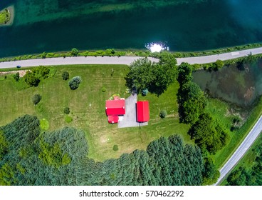 Single Farm House In A Rural Area Beside A Lake Aerial Top View