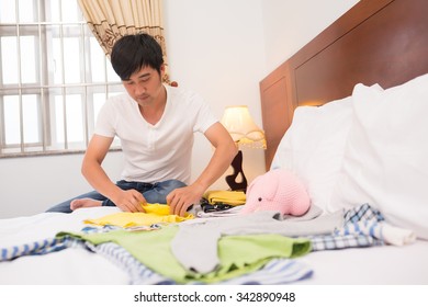 Single father folding clothes of his child after laundry - Powered by Shutterstock