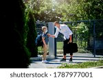 Single father going to work and taking son to school during epidemic. They are wearing a face mask.