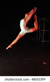 Single Female Modern Dancer During Dance Training Session On Stage. Lit With Spotlights