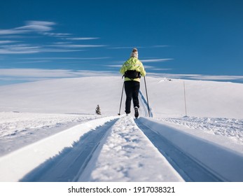 Single female skier following a well groomed track in the norwegian mountains at easter