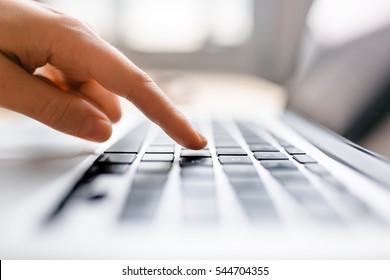 Single Finger Press Button On Laptop Keyboard, Close Up Clean Image With Sun Flare